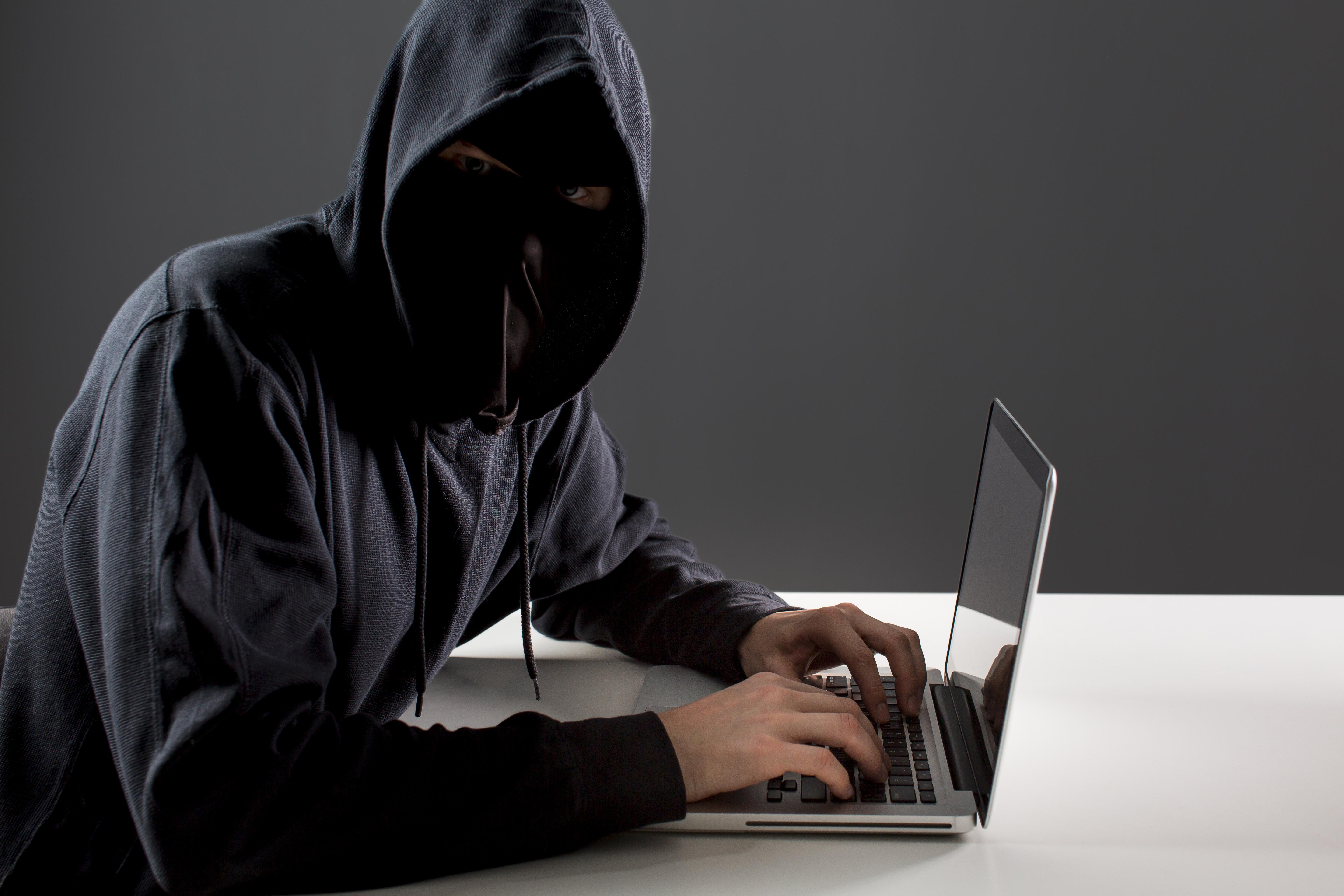 side-view-male-hacker-with-laptop