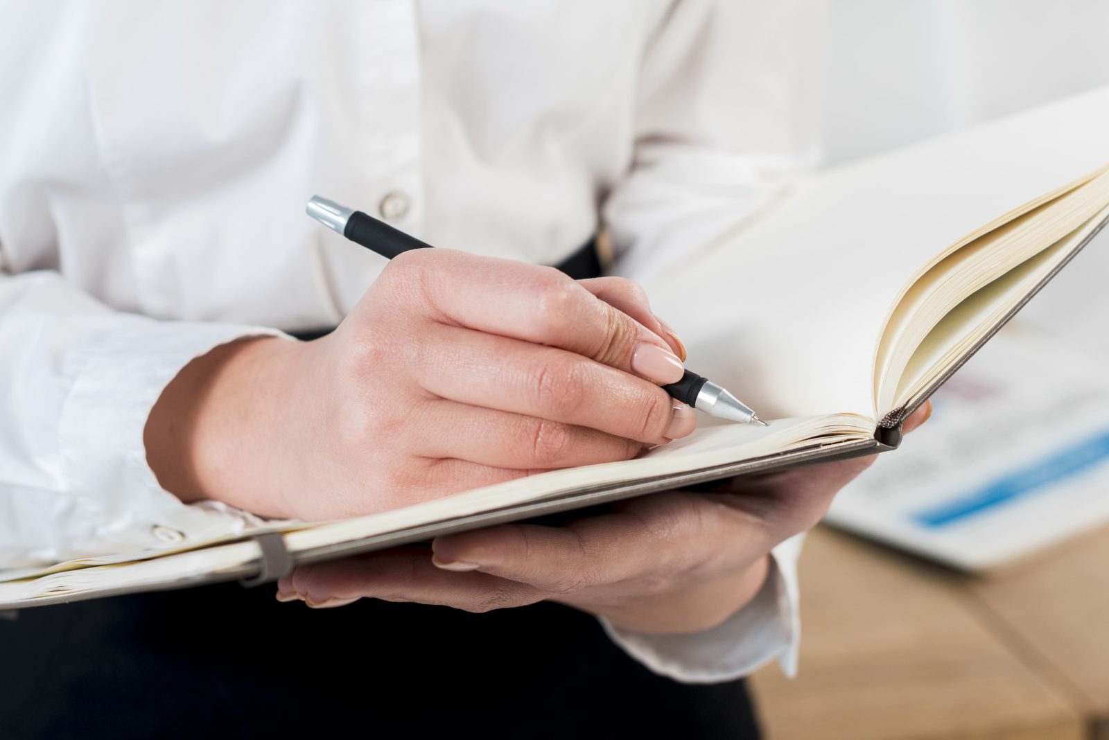 close-up-businesswoman-s-hand-writing-diary-with-pen