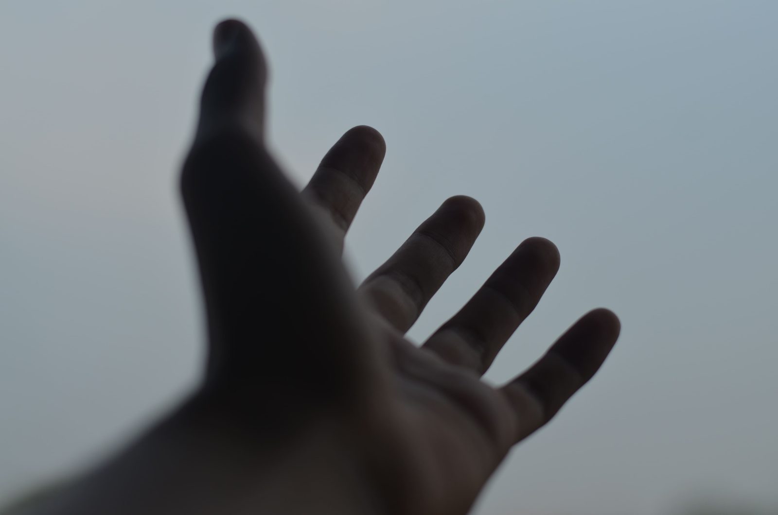 close-up-hand-gesturing-against-sky
