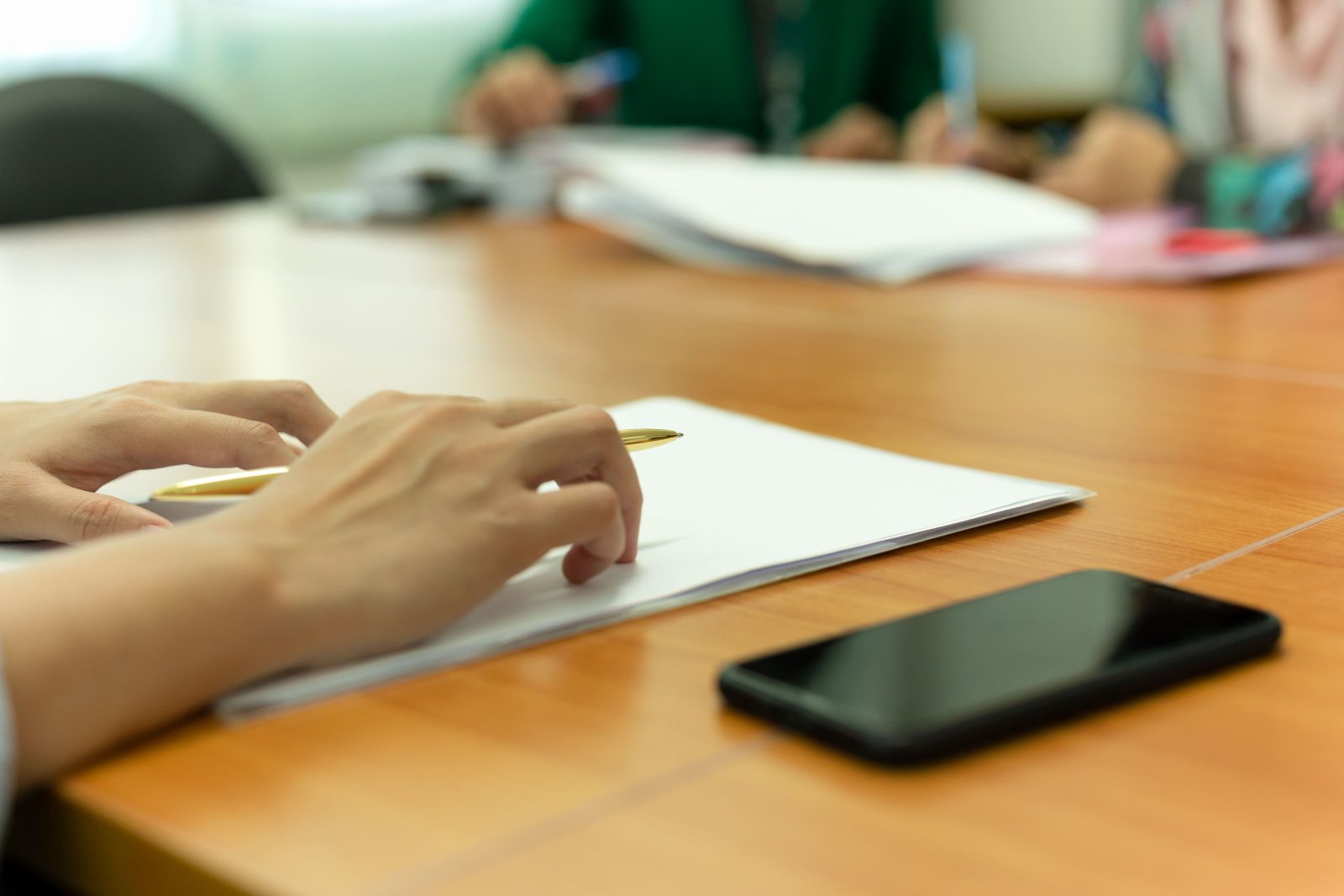 hand-holding-pen-while-presenting-his-document-office-meeting