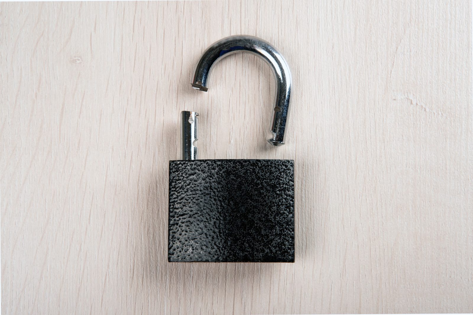 broken-padlock-wooden-background-close-up